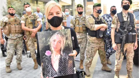 Getty Images Woman holds picture of person killed in Beirut port explosion (file photo)