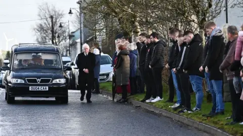 PACEMAKER Mourners line the route of Peter McNamee's funeral on Saturday