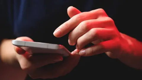 Getty Images Person holding mobile phone