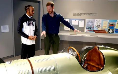 Peter Nicholls / AFP Prince Harry and Formula One world champion driver Lewis Hamilton look at a car