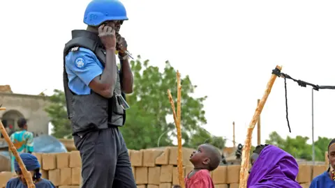 AFP A child watches a UN peacekeeper on patrol through the streets Gao, Mali - August 2018