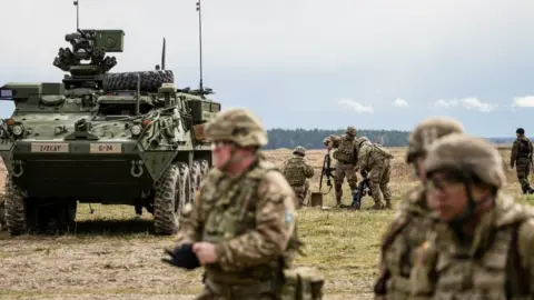 Getty Images US soldiers are pictured prior the beginning of the official welcoming ceremony of Nato troops in Orzysz, Poland, on April 13, 2017