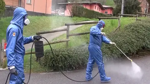 Getty Images Russian military specialists disinfect in Vertova, 31 Mar 20 (Tass via Getty Images)