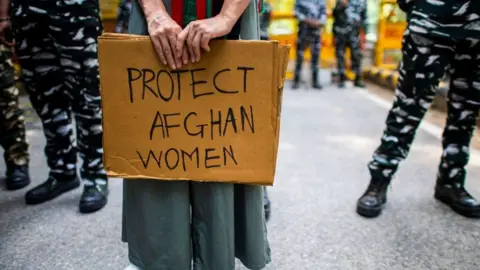 Getty Images An Afghan woman exile in India displays a placard as she takes part in an anti-Taliban demonstration in New Delhi on August 23, 2021