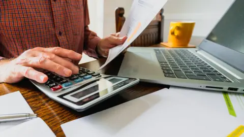 Getty Images Man dealing with household bills