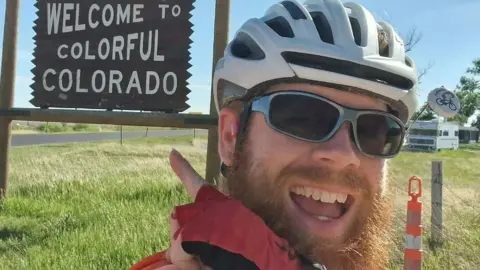 Antony Butcher Anthony Butcher next to a Colorado sign