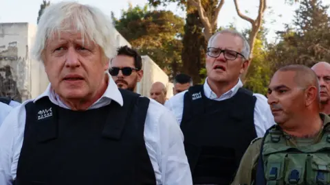 Reuters In November, Former PM Boris Johnson and ex-Australian PM Scott Morrison visited Kibbutz Kfar Aza following the 7 October attack by Hamas gunmen from the Gaza Strip