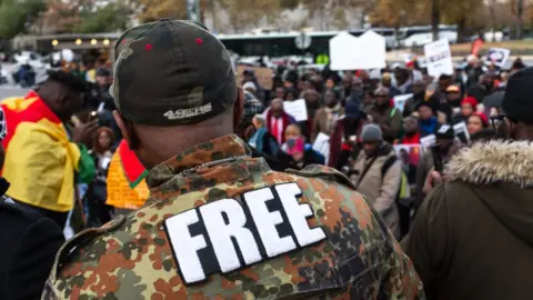 Getty Images Anti-Paul Biya Protesters demonstrate in front of the Eiffel tower in Paris, France, on 27 October 2018.