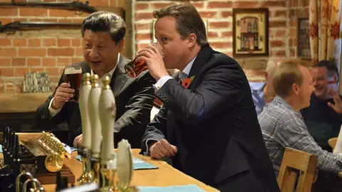 Getty Images China's President Xi Jinping and then-UK Prime Minister David Cameron share a pint at a pub in 2015.