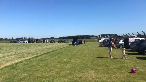 Vehicles lined up at the end fence