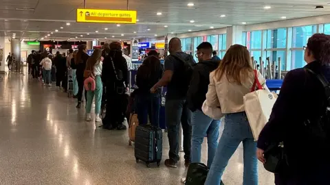 PA Media Passengers queuing at Heathrow