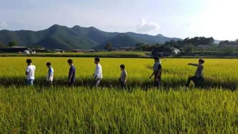 Kim Tae-hoon Kim's foster family in a field, South Korea