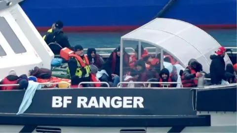 PA Media A group of people thought to be migrants are brought in to Dover, Kent, onboard a Border Force vessel following a small boat incident in the Channel.