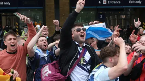 PA Media fans arrive at King's Cross Station