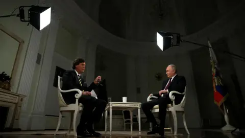 Reuters Vladimir Putin and Tucker Carlson