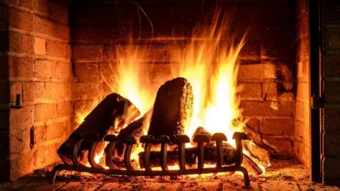 Getty Images Wood burning in a fireplace