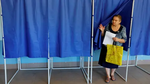 Reuters A woman walks out of a voting booth at a polling station during local elections held by the Russian-installed authorities in the course of Russia-Ukraine conflict in Donetsk, Russian-controlled Ukraine, September 8, 2023