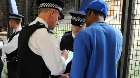 PA Media Metropolitan Police officers set up a stop and search operation