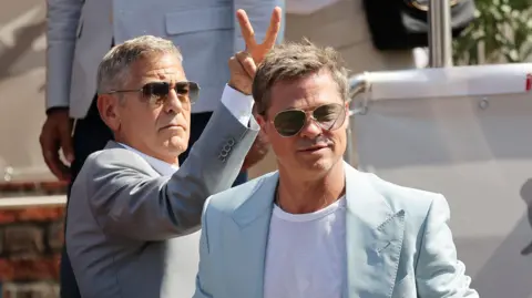 Getty Images Cast members Brad Pitt and George Clooney arrive via boat to the premiere of "Wolfs" out of competition, at the 81st Venice Film Festival, Venice, Italy, September 1, 2024