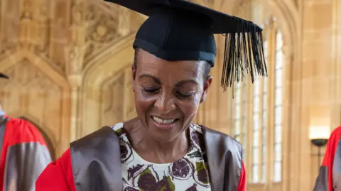 University of Oxford Actress and theatre director Adjoa Andoh. She is wearing a cap and a red gown.