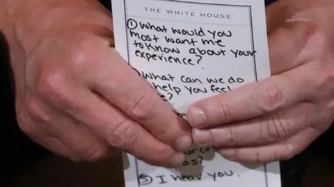 Reuters US President Donald Trump holds his prepared questions as he hosts a listening session with high school students