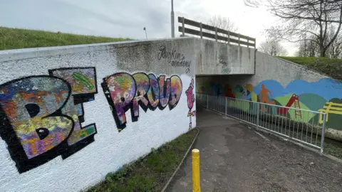 Ben Schofield/BBC An underpass in Queensway tagged with graffiti saying "be proud"