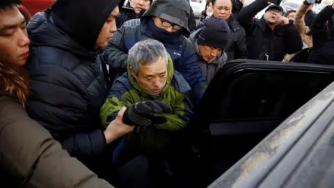 Reuters A supporter of prominent rights lawyer Wang Quanzhang is detained outside the courthouse where his trial is held, in Tianjin, China December 26, 2018.