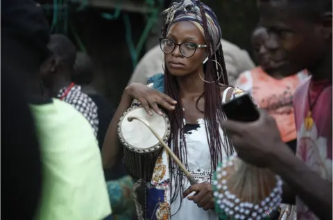 EPA Ayanbinrin Aduke plays a drum during the 80th birthday celebration for uncle Jumi Solanke, as he is fondly called, in the Bariga district of Lagos, Nigeria, 06 July 2022. The Lagos Art community celebrated one of Nigeria"s foremost art directors, dramatist, and storytellers, with book readings, stage play, film screening and story-telling events.