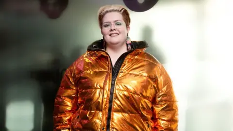 BBC Jayde Adams wearing a big copper coloured puffa jacket