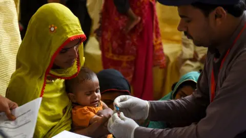 AFP A mother holds her child, who is tested for HIV