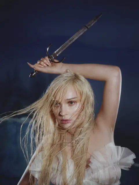 Luke Gifford Kim Petras holds aloft a dagger in a promotional image for her debut albun, Feed The Beast, in June 2023