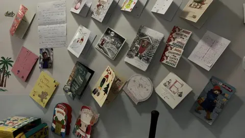 Chloe Green Christmas cards on a wall