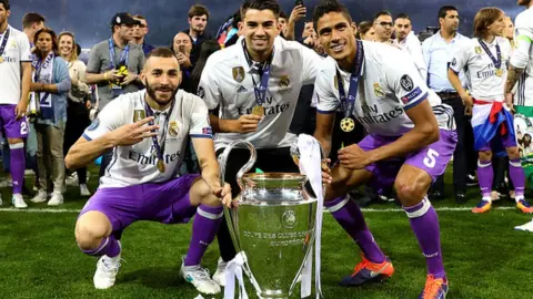 Getty Images Karim Benzema, Enzo Fernandez and Raphael Varane of Real Madrid with the Champions League trophy