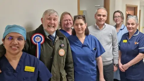 Hinchingbrooke Hospital Colin Bedford with staff at Hinchingbrooke Hospital