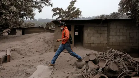 Reuters A man steps through debris in an area affected by eruption from Fuego volcano in the community of San Miguel Los Lotes in Escuintla, Guatemala June 4, 2018