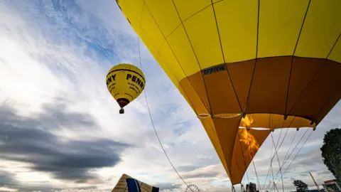 Ben Birchall/PA Wire Hot air balloons in the sky