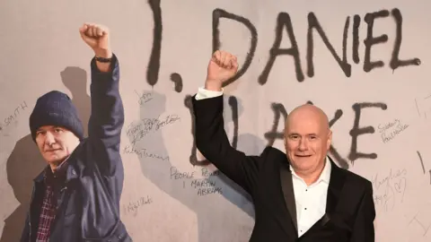 Getty Images Dave Johns in front of a poster for I, Daniel Blake at the film's premiere in 2016