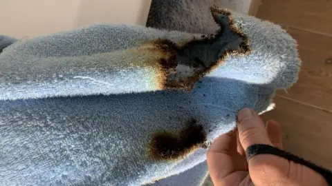 A blue dressing gown with fire damage