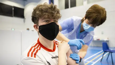 Liam McBurney/PA Wire Young man being vaccinated