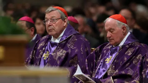 Getty Images Cardinal George Pell (l) listens to a mass, while sitting among other cardinals at St Peter's Basilica on February 10, 2016 in Vatican City