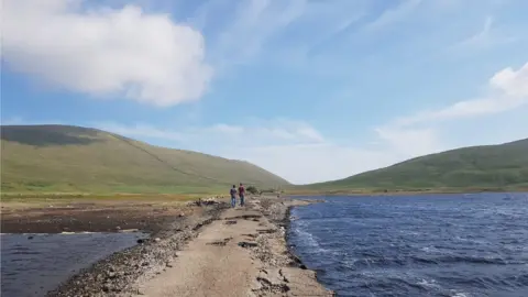 People walking along the old road at Spelga Reservoir