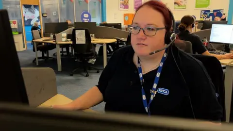 A female call handler working in an office