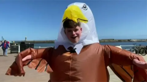 Corey looking at camera in eagle suit