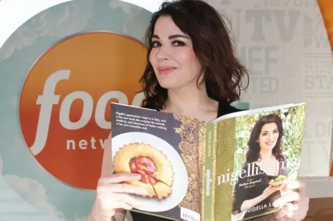 Getty Images Nigella Lawson with one of her multiple cook books