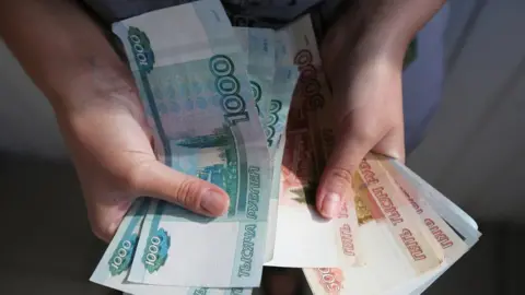 Getty Images Person holding roubles