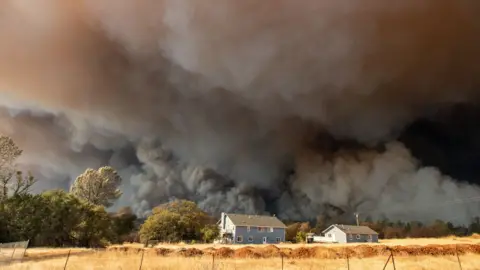 Getty Images A home is overshadowed by towering smoke plumes as the Camp fire races through California on November 8 2018