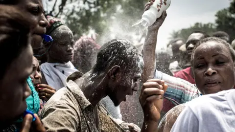 AFP A supporter of Felix Tshisekedi being showered with power in Kinshasa, DR Congo - Thursday 10 January 2019