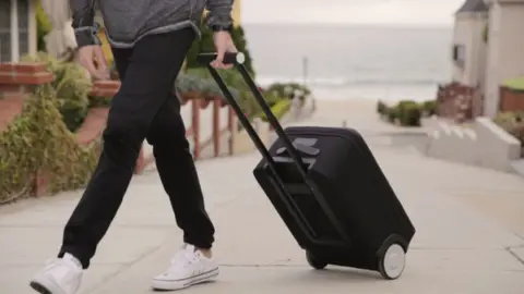 Morrama Person wheeling a suitcase