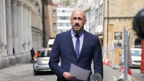 Det Insp Keith Smith stands outside Bristol Crown Court with a statement in his hand