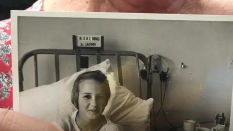 Susan Payne holding a childhood photo